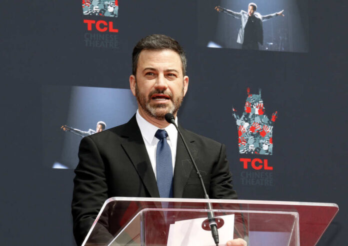 A man in a suit speaking at a podium during a ceremony at TCL Chinese Theatre