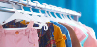 A variety of children's clothing hanging on a rack