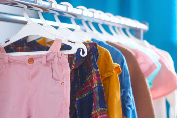 A variety of children's clothing hanging on a rack