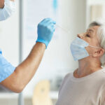 Healthcare worker administering a nasal swab test to an elderly woman