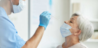 Healthcare worker administering a nasal swab test to an elderly woman