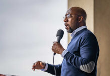 A man speaking into a microphone at an outdoor event