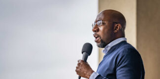 A man speaking into a microphone at an outdoor event