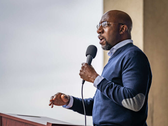 A man speaking into a microphone at an outdoor event