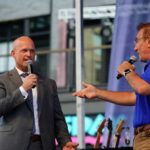 Internal REVOLT: Heritage Faces Crisis Over Carlson Praise Two speakers engaging with each other on stage at an outdoor event