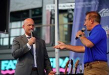 Two speakers engaging with each other on stage at an outdoor event