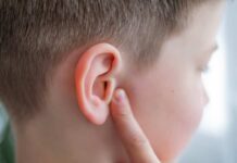 Hearing Restored Without Implants — Miracle Treatment! Child touching their ear with a concerned expression