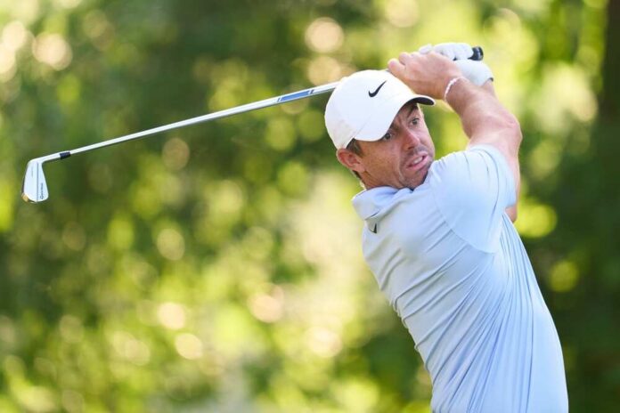 shutterstock_2464426169.jpg A golfer in mid-swing on a lush green course