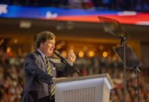 A speaker passionately addressing an audience from a podium