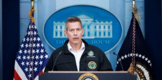 Government official speaking at a podium in the White House briefing room