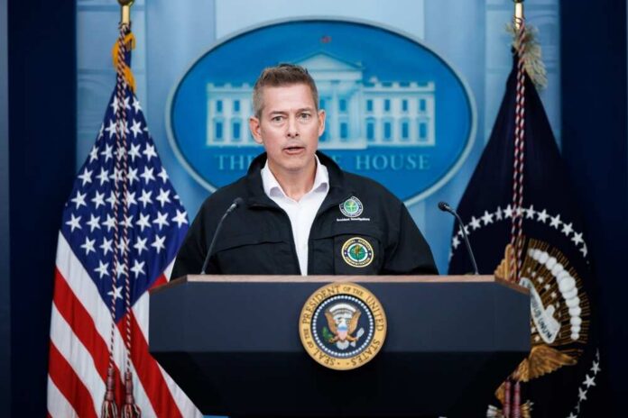 Government official speaking at a podium in the White House briefing room