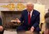 Trump’s Iran Pause: What’s the REAL Deal? A man in a blue suit and red tie gesturing during a discussion in a formal setting