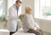 Doctor examining an elderly patient in a bright medical office