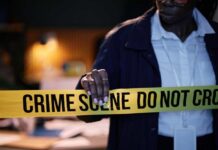 Police officer holding crime scene tape