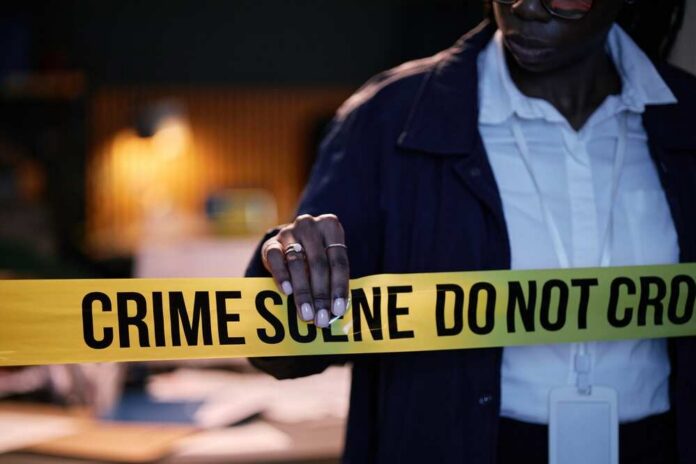 Police officer holding crime scene tape