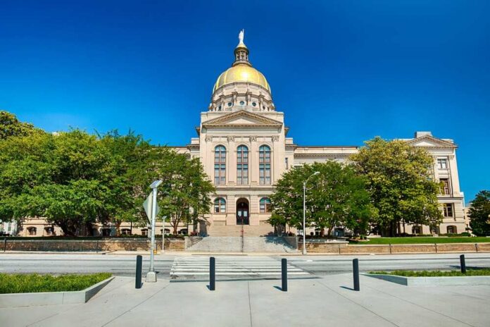 Front view of a government building with a golden dome and surrounding greenery