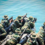 Soldiers in camouflage gear on a boat preparing for a mission