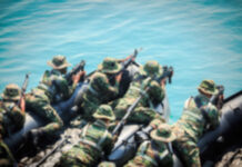 Soldiers in camouflage gear on a boat preparing for a mission