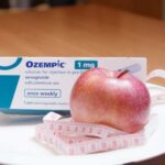 Fiscal Nightmare: Town Budgets Crumble Under Drug Costs Ozempic medication box next to a red apple and measuring tape on a plate