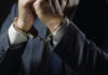 Businessperson in suit with hands cuffed together