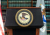 U.S. Department of Justice podium with seal.