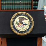 U.S. Department of Justice podium with seal.