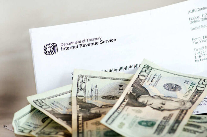 irs-30766607 IRS letter with scattered U.S. dollar bills.
