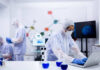 Scientists in a lab conducting research with equipment and a computer