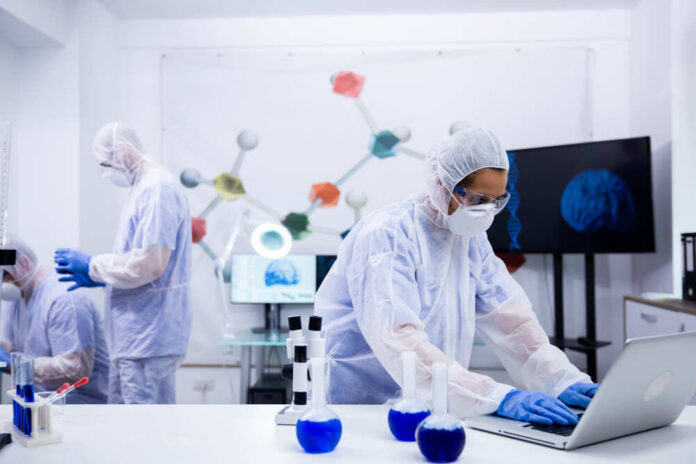 Scientists in a lab conducting research with equipment and a computer
