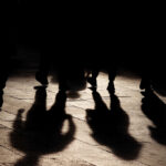 Criminal Gangs: Iran’s Secret Weapon in Europe Silhouettes of people walking, casting shadows on the ground