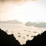 A tranquil view of islands and boats on calm water during sunset