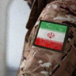 Iran Vows War “Likely” – Ceasefire in Jeopardy Close-up of a military uniform with an Iranian flag patch