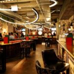 Interior view of a modern bar with decorative lighting and patrons