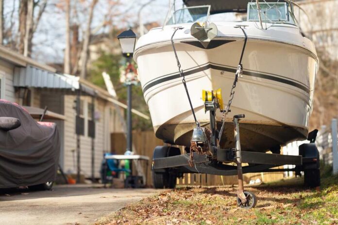 A boat on a trailer parked in a residential area