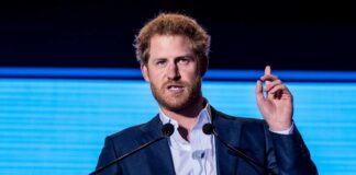A man in a suit speaking at a podium during a conference