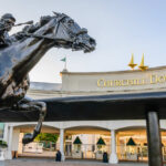 Bronze statue of a horse and jockey in front of Churchill Downs