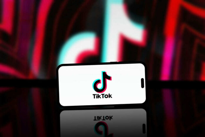 tiktokid2449600225jpg Smartphone displaying TikTok logo on screen
