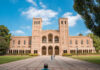 Romanesque brick university building with two towers and arched colonnade