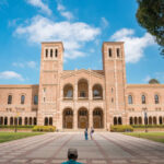 Romanesque brick university building with two towers and arched colonnade
