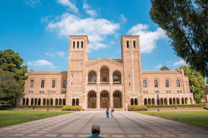 Romanesque brick university building with two towers and arched colonnade