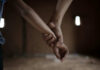 A Reckoning Decades In The Making Close-up of one hand gripping another person's wrist