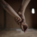 Close-up of one hand gripping another person's wrist