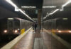 Subway platform with arriving train and commuters waiting