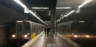 Subway platform with arriving train and commuters waiting