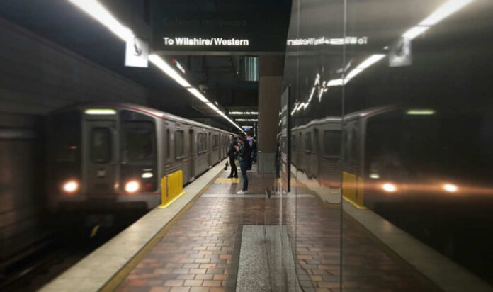 Subway platform with arriving train and commuters waiting