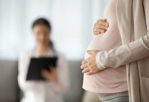 Catholic Bishops Fight DC Power Grab Pregnant person holding their belly during a medical visit