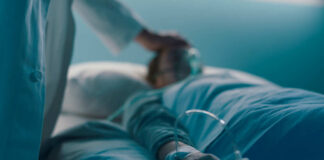 A medical professional attending to a patient in a hospital bed