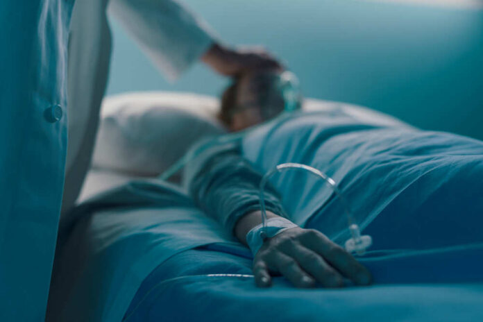 A medical professional attending to a patient in a hospital bed