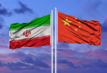 Beijing-Iran Link Sends Pilots on Edge Flags of Iran and China waving against a colorful sky
