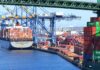 A cargo ship loaded with colorful containers docked at a busy shipping port